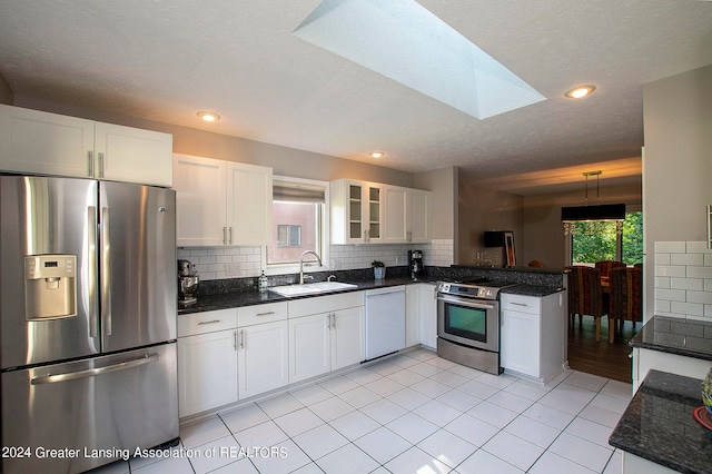 kitchen featuring decorative light fixtures, white cabinets, appliances with stainless steel finishes, and sink