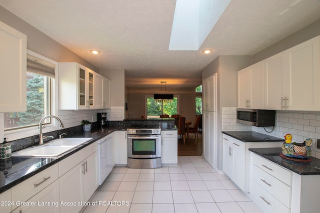 kitchen with white cabinetry, plenty of natural light, stainless steel appliances, and sink