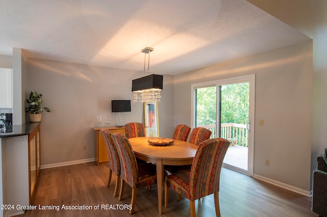 dining area featuring a textured ceiling and light hardwood / wood-style floors