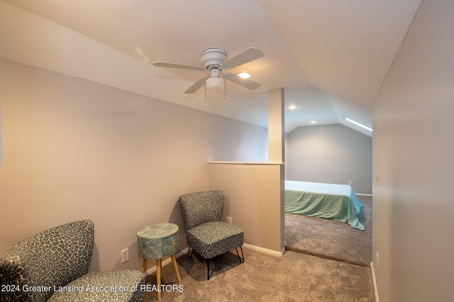 living area with lofted ceiling, ceiling fan, and light carpet