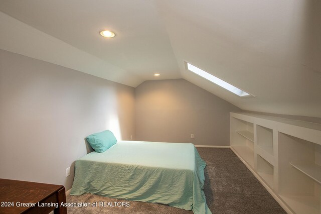 bedroom with vaulted ceiling with skylight and dark carpet