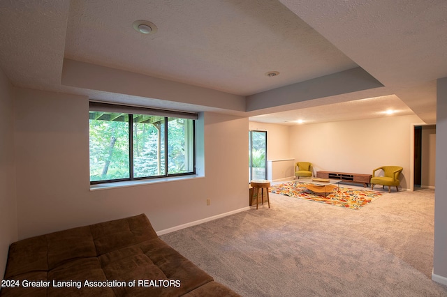 unfurnished living room with a wealth of natural light, a textured ceiling, and carpet floors