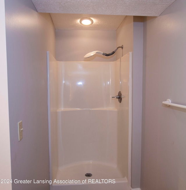 bathroom featuring a textured ceiling and walk in shower