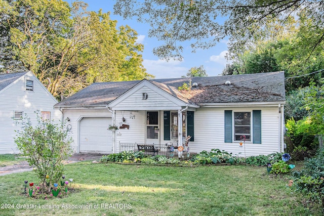 view of front of property featuring a front yard, a porch, an attached garage, and roof with shingles