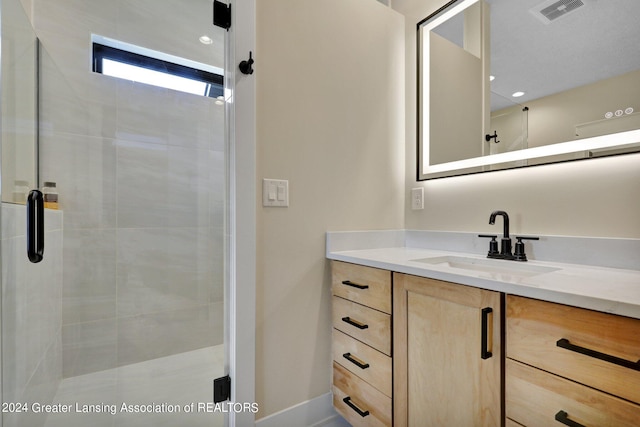 bathroom featuring vanity and a shower with shower door