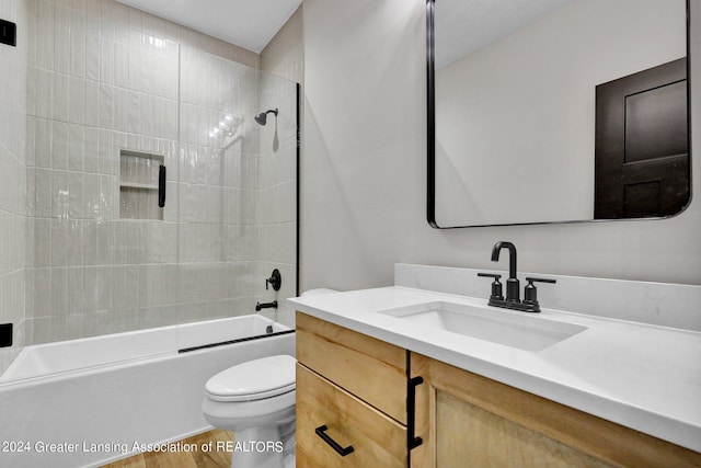 full bathroom with tiled shower / bath combo, vanity, toilet, and hardwood / wood-style flooring