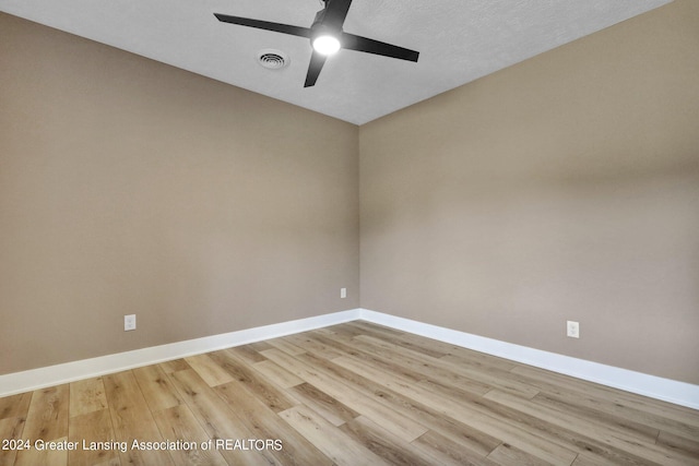 spare room with a textured ceiling, light hardwood / wood-style flooring, and ceiling fan