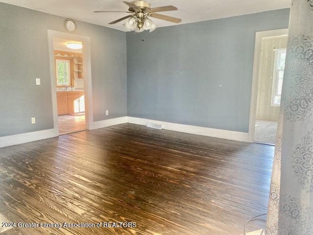 spare room with a ceiling fan, baseboards, and wood finished floors