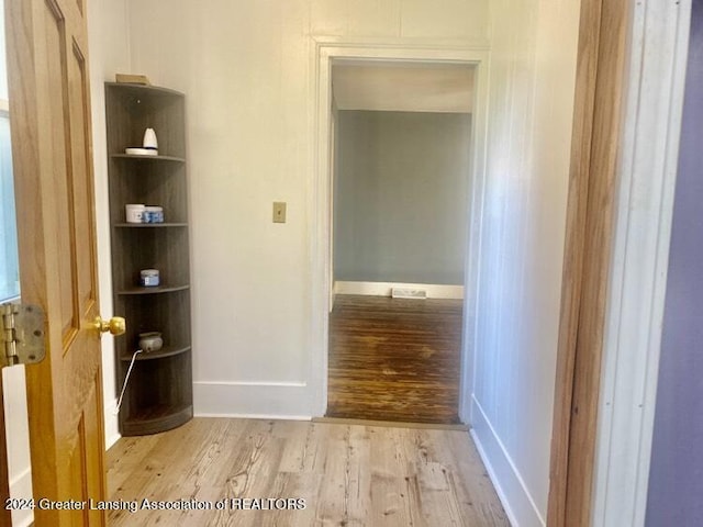 hallway featuring baseboards and wood finished floors