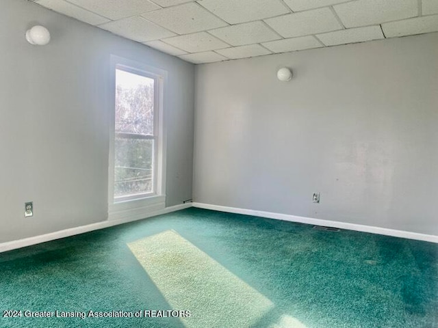 spare room with carpet floors and a drop ceiling