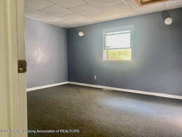 carpeted spare room with a drop ceiling