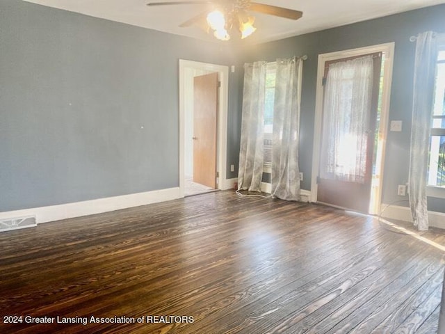 unfurnished room featuring baseboards, visible vents, ceiling fan, and hardwood / wood-style flooring