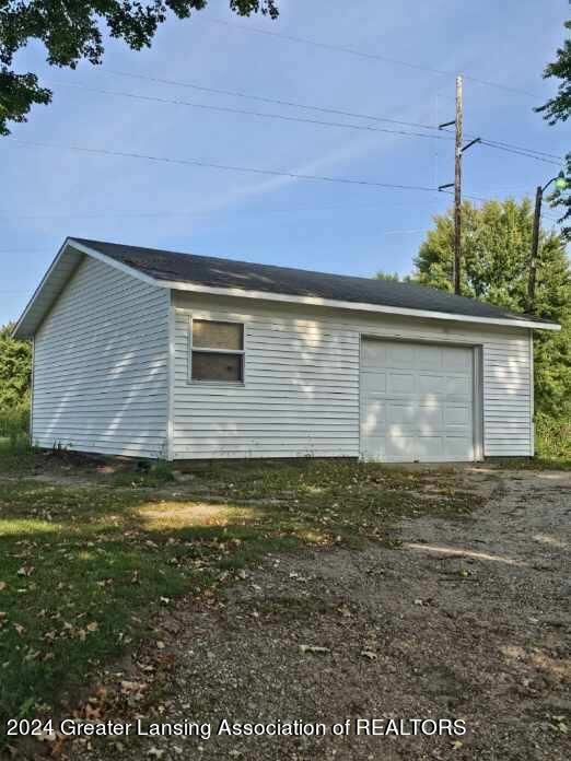 view of side of property featuring driveway and an outbuilding