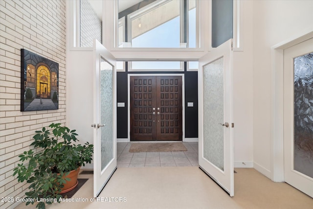 foyer featuring light tile patterned floors and a high ceiling