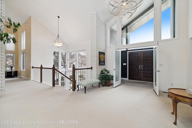 carpeted entryway with high vaulted ceiling