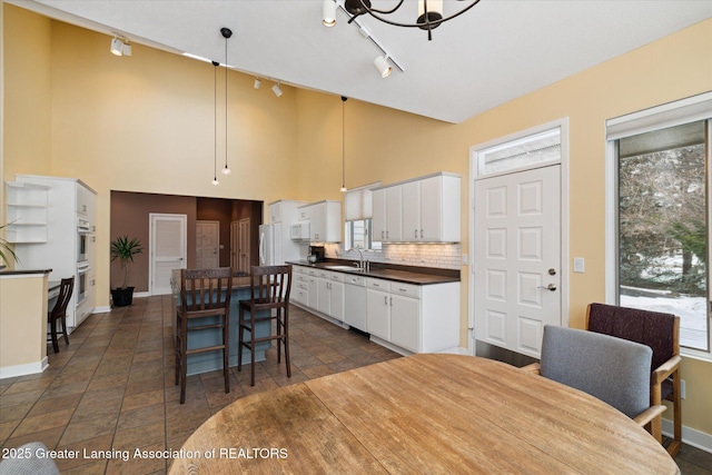 dining area featuring sink and a towering ceiling