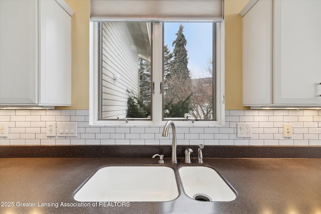 kitchen with sink, white cabinets, and backsplash