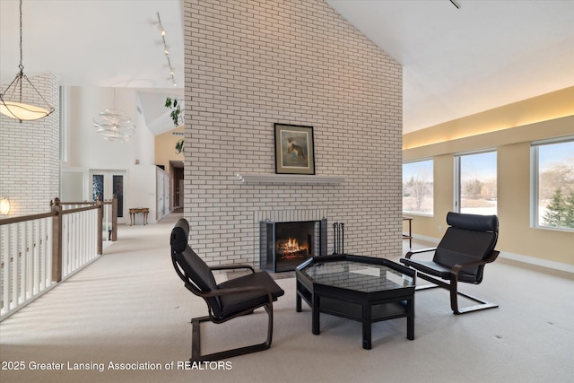 sitting room featuring high vaulted ceiling, a fireplace, light colored carpet, track lighting, and french doors