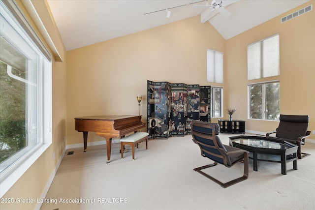 sitting room with ceiling fan, high vaulted ceiling, rail lighting, and carpet floors