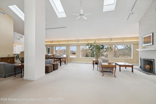 living room featuring a brick fireplace, carpet floors, high vaulted ceiling, and track lighting