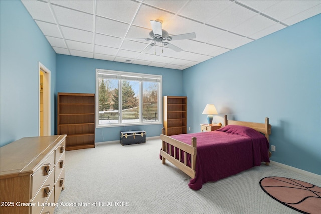 carpeted bedroom with a drop ceiling and ceiling fan