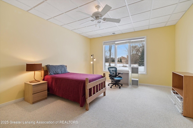 bedroom with light colored carpet, a drop ceiling, and ceiling fan