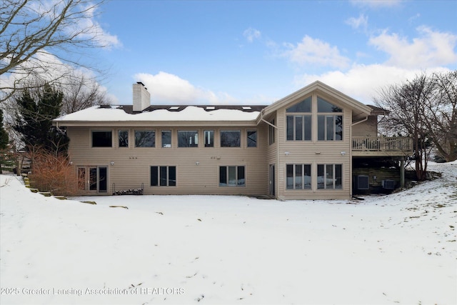 snow covered rear of property featuring a deck