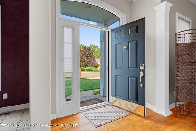 entrance foyer featuring hardwood / wood-style floors and ornate columns