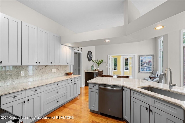 kitchen featuring dishwasher, light wood-type flooring, light stone countertops, sink, and gray cabinets