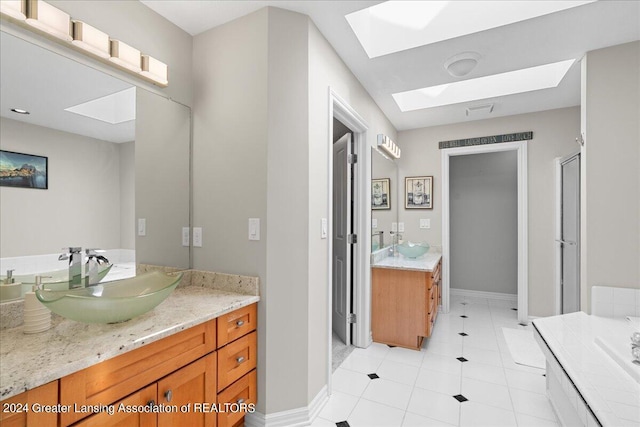 bathroom with tile patterned floors, a skylight, walk in shower, and vanity