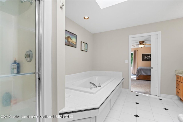 bathroom featuring vanity, shower with separate bathtub, tile patterned floors, a skylight, and ceiling fan