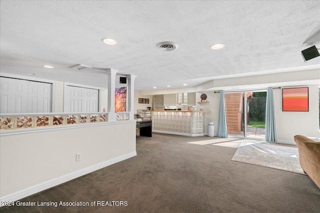 unfurnished living room featuring a textured ceiling and carpet floors