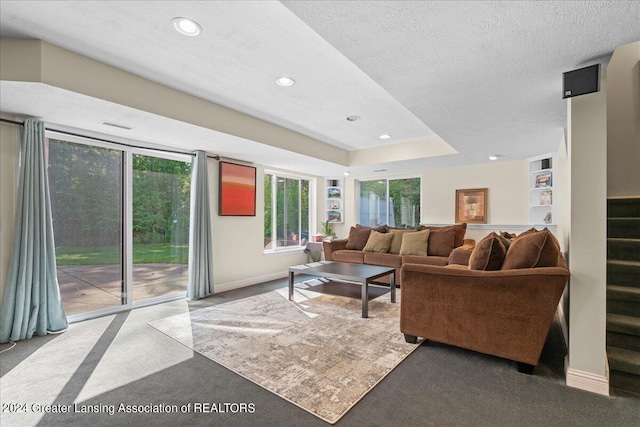 carpeted living room featuring a textured ceiling