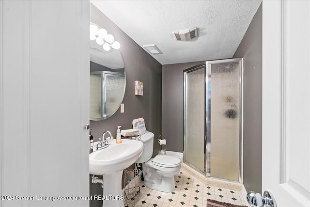 bathroom featuring toilet, an enclosed shower, and a textured ceiling