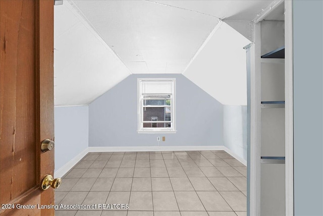 additional living space with vaulted ceiling and light tile patterned floors