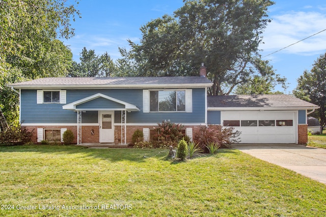 raised ranch with a garage and a front lawn