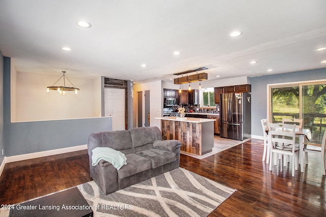 living room with dark wood-type flooring and a chandelier