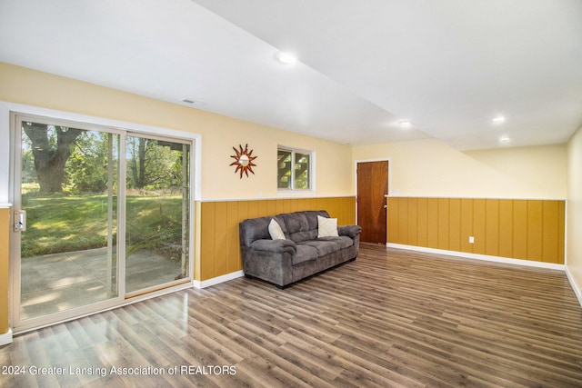 unfurnished room featuring a healthy amount of sunlight, wood-type flooring, and wooden walls