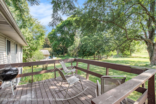 wooden deck featuring grilling area and a yard