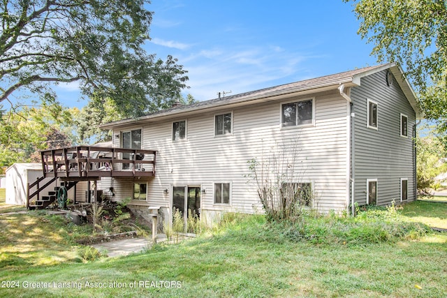 back of house with a wooden deck and a lawn