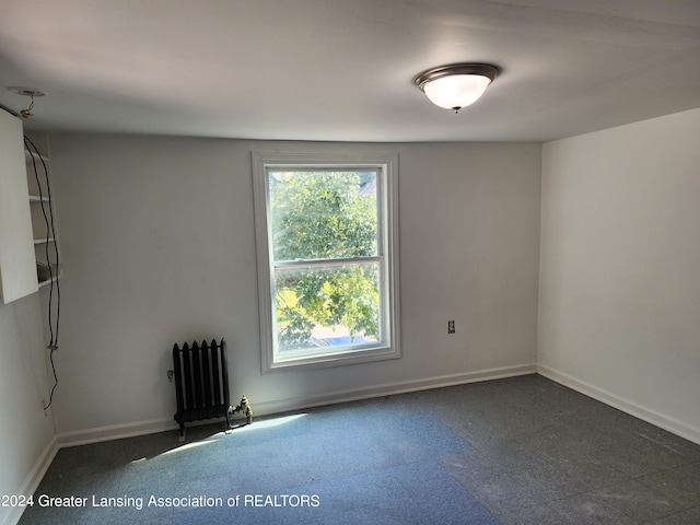 unfurnished room with radiator heating unit