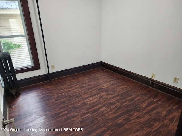 spare room with dark hardwood / wood-style flooring