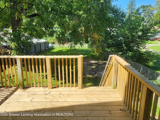 wooden terrace featuring a lawn