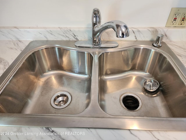 interior details featuring light stone countertops and sink