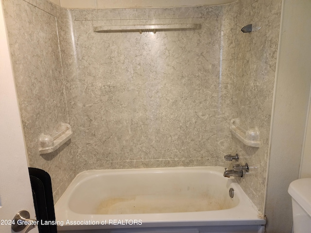 bathroom with washtub / shower combination and toilet