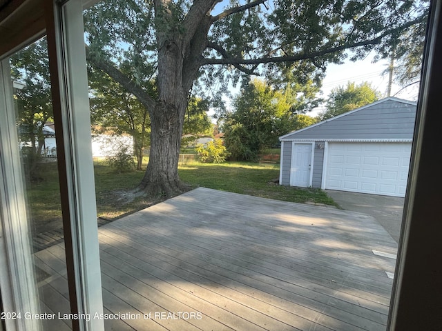 wooden deck featuring a yard, an outbuilding, and a garage