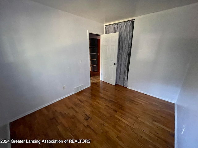 unfurnished room with dark hardwood / wood-style floors