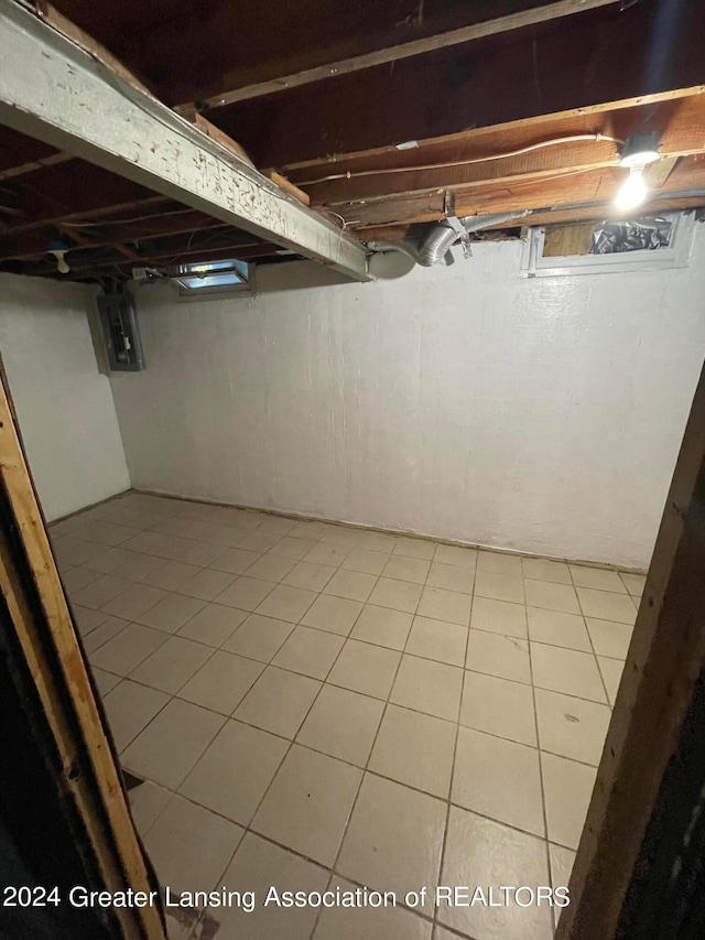 basement with electric panel and light tile patterned floors