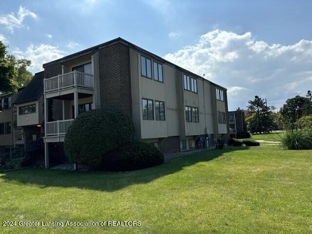 view of property exterior featuring a lawn and a balcony