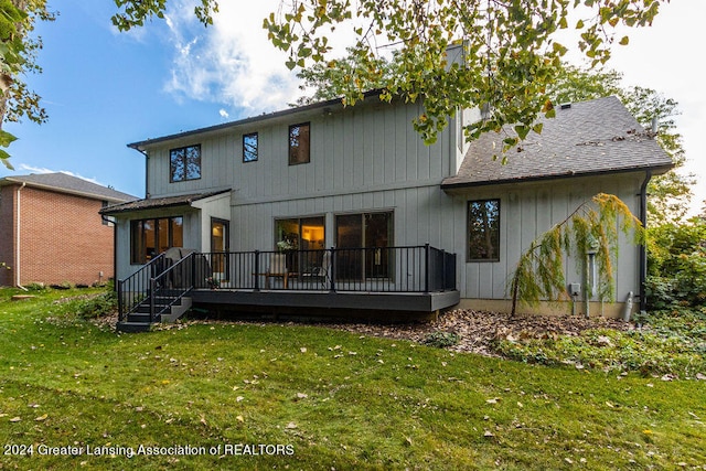 rear view of property with a yard and a wooden deck